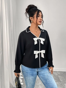Detailed view of black Polo collar jacket featuring white bow accents and ruffled cuffs