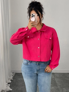 Detail of rose red corduroy jacket featuring silver metal buttons and chest pockets