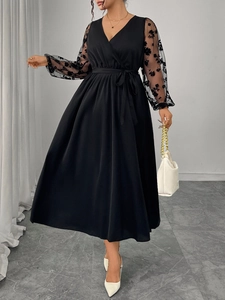 Detail of elegant V-neck dress with sheer floral lace sleeves and belted waistline