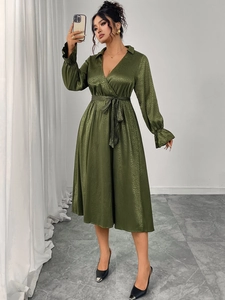 Detail of emerald green jacquard wrap dress with waist tie and pleated cuffs