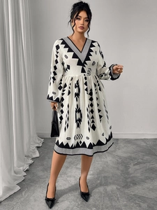 Close-up of white V-neck midi dress with black geometric patterns and high waist design