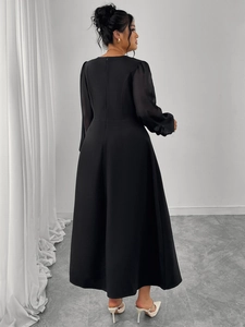 Detail view of the elegant black A-line dress with long sheer sleeves and back hidden zipper