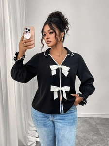 Close-up of black polo collar jacket with white ruffle edges and delicate bow details