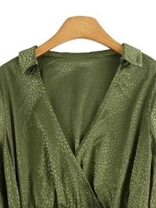 Detail of olive green satin V-neck dress with leopard jacquard texture and wrap design