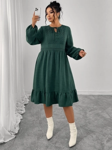 Détails de dentelle ajourée et col à nouer sur cette élégante robe longue vert foncé chic
