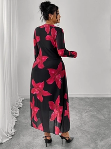 Detail of the back profile of a black floral maxi dress with vibrant red lily patterns