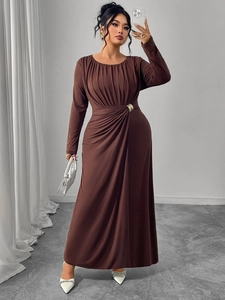 Detail of waist-cinching pleats and golden metal ring on brown long-sleeved dress