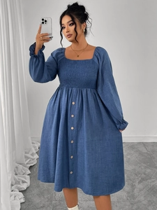 Detail of square neckline with elastic smocked chest and wooden buttons on a blue dress