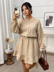 Détail de la robe beige texturée montrant les boutons et la taille élastique haute