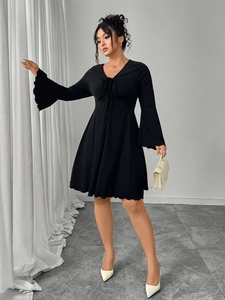 Detail of elegant black V-neck dress featuring wide bell sleeves and drawstring bust design