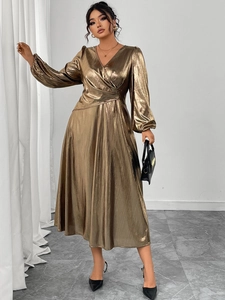 Detail view of metallic gold V-neck dress with lantern sleeves and pleated fabric texture