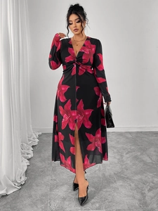 Detail of V-neck floral dress with twisted knot and red flower pattern on black fabric