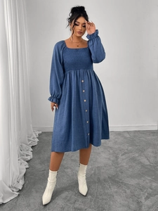 Detail view of blue square neck dress featuring elastic smocking and front button accents