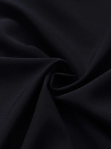 Detailed close-up of premium black woven fabric texture with silk-like luster and drape