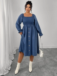 Detail of square neck blue dress featuring smocked bodice and decorative front buttons