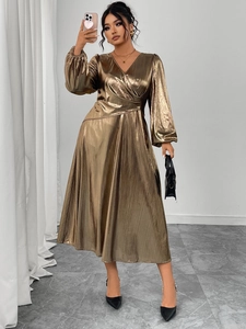 Macro shot of metallic gold pleated dress fabric with deep V-neck and high waist detail
