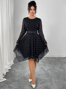 Detail of a black chiffon dress with white bow prints and tiered asymmetrical skirt