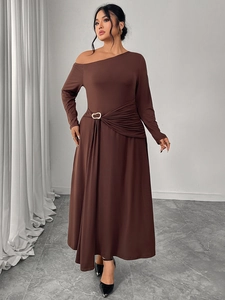 Detail of waist pleated design with a golden heart-shaped buckle on a coffee brown dress