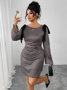 Detail of black bows on shoulders and black and white plaid long sleeve dress