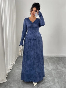 Detail view of the V-neckline and elegant pleated waist of a navy marble long sleeve dress