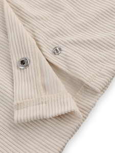 Close-up of cream corduroy texture and silver metal snap buttons on woman jacket