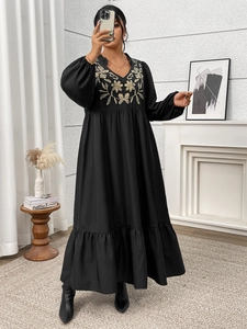 Detail of V-neck long dress featuring gold floral embroidery and stylish lantern sleeves