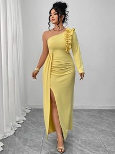 Detail of yellow one-shoulder evening gown featuring ruffled shoulder and high slit design