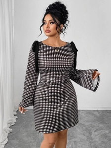 Detail of shoulder black ribbon bows on a slim-fit black and white plaid dress