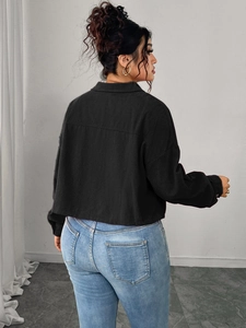 Detailed texture of black corduroy jacket featuring drop shoulders and loose lantern sleeves