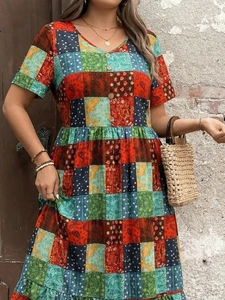Detailed view of bohemian V-neck dress featuring colorful paisley patchwork and wooden buttons