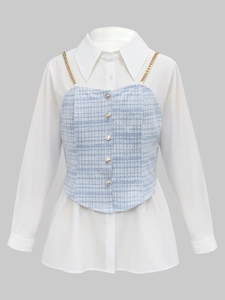 Close-up of blue tweed camisole with metal chain straps over a white long-sleeve shirt