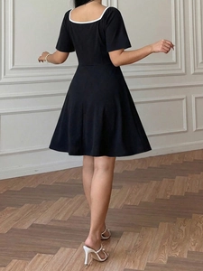 Detail view of black A-line dress back with contrast square collar and slim waist