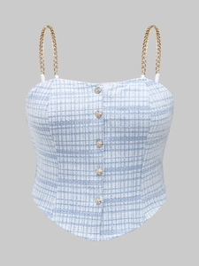 Detail of blue plaid tweed corset top with gold chain straps and textured buttons