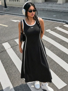 Dettaglio di un abito sportivo nero senza maniche a trapezio con strisce bianche e patch California
