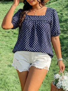 Detail of square neck polka dot blouse with puff sleeves in navy blue summer outfit