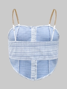 Detail of light blue tweed vest with gold chain straps and structured boning seams