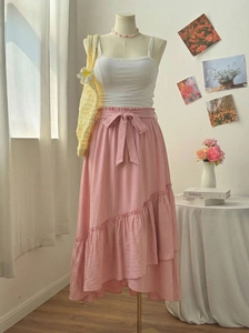 Détail d'une jupe midi rose à volants avec taille élastique et nœud décoratif