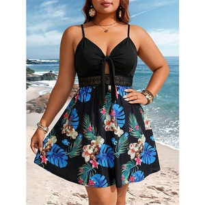 Plus size summer dress with black bodice and tropical floral print skirt on beach