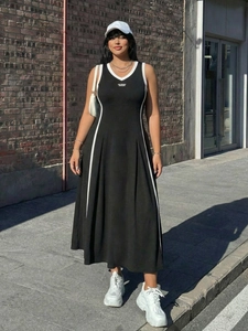 Vista street style di un abito sportivo nero con bordi bianchi e gonna lunga a pieghe