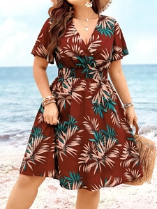 Nahaufnahme des V-Ausschnitts und des tropischen Palmenmusters auf einem Sommer-Maxikleid