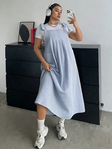 Detail of blue and white striped pinafore dress with knot tie shoulder straps and pockets