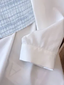Close-up of white long sleeve shirt cuff and blue tweed fabric texture contrast