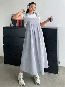 Detail showing adjustable bow shoulder straps on blue striped pinafore midi dress