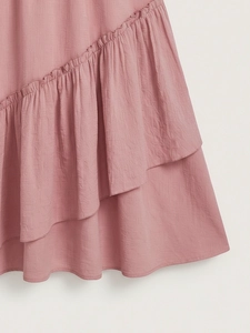 Macro detail of dusty pink ruffled skirt featuring layered crepe fabric and elegant stitching