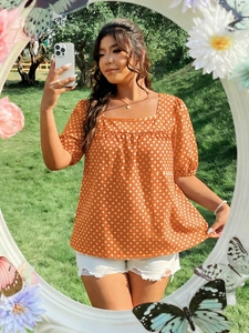Detailed close-up of square neckline and puff sleeves on orange polka dot doll blouse