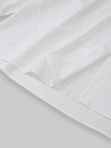 Detail of the white shirt showing precision double-stitching and side split hem