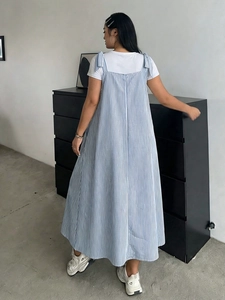 Detail of blue and white striped dress with bow shoulder straps and flared hem silhouette