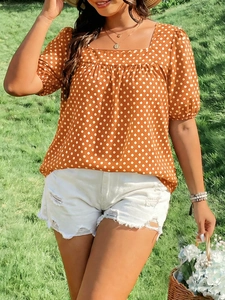 Detail of square neck summer top with white polka dots and puff sleeves in brick red