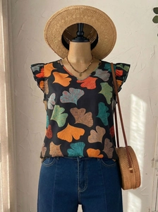 Detail of V-neck printed top with ruffle sleeves styled with summer accessories