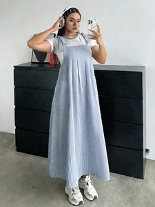Detailed view of striped pinafore dress featuring adjustable shoulder ties and pockets